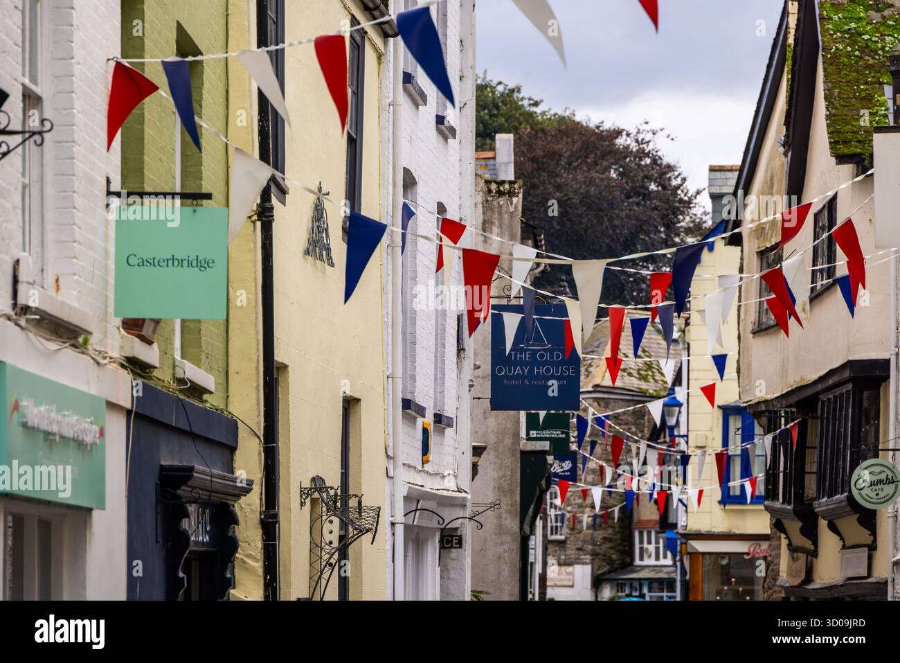 Fore St decorated with bunting and with shops, pubs, inns and restaurants in the port town of Fowey, Cornwall, Englang, UK, Europe Stock Photo