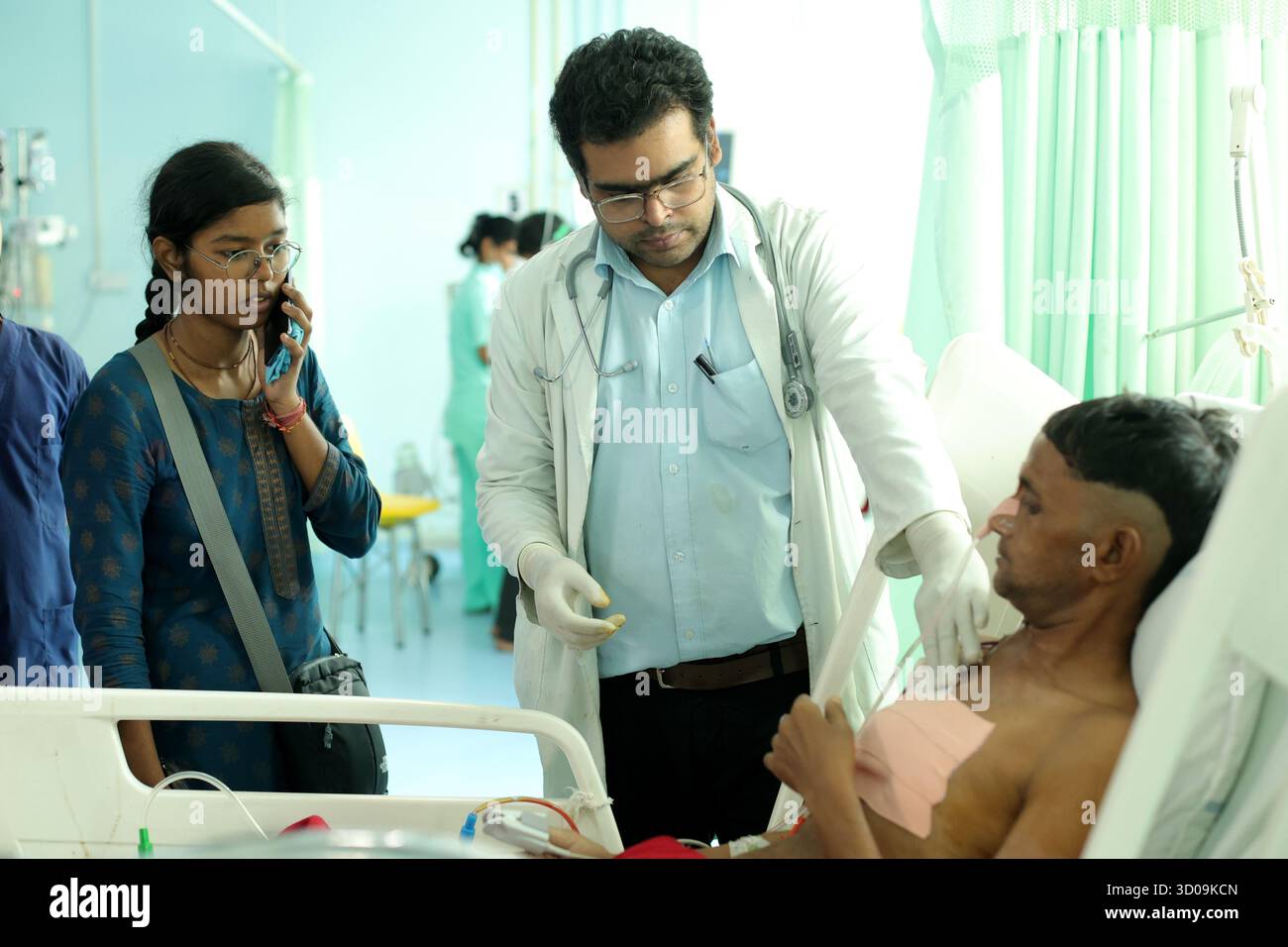 A Group of Doctors examin a patient at ICU (Intensive Care Unit) ward ...