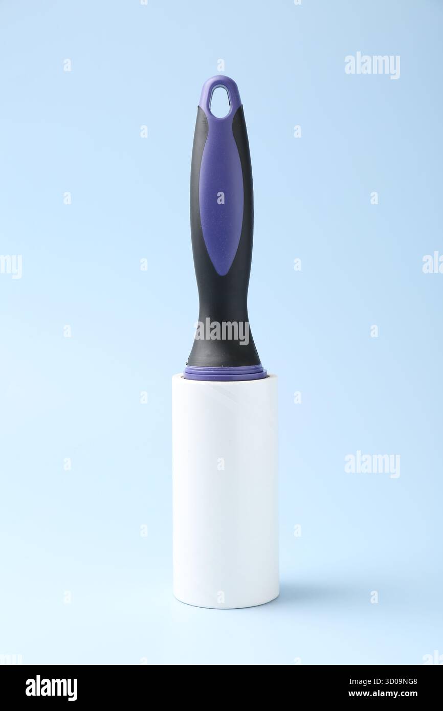One lint roller on light blue background Stock Photo