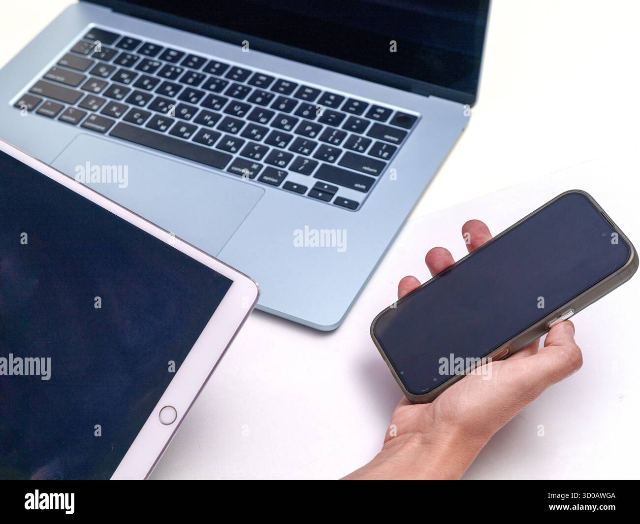 Modern Digital Devices: Laptop, Tablet, and Smartphone in Use Stock Photo