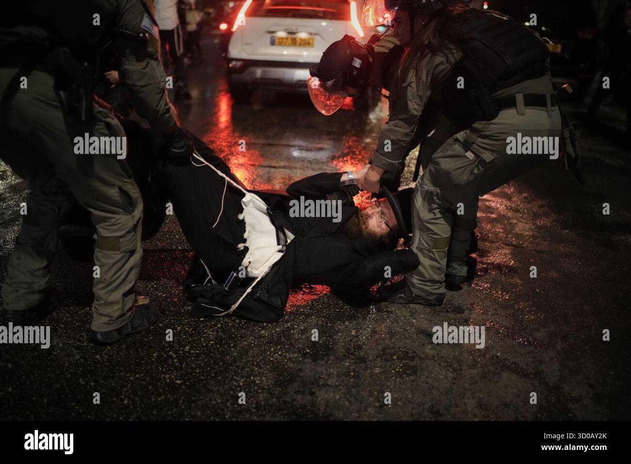Police try to disperse ultra-Orthodox Jewish men blocking a street ...
