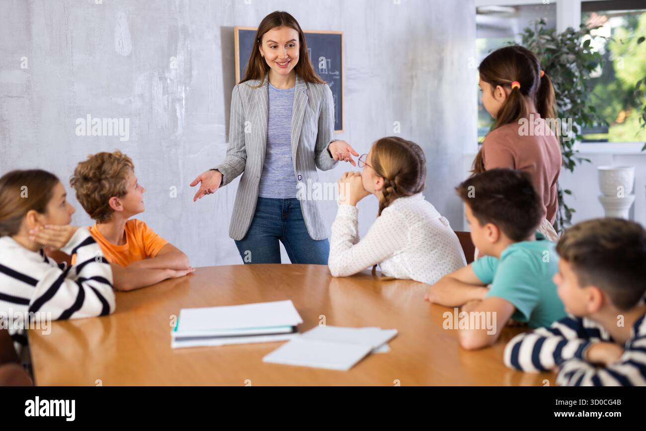 Portrait of female teacher giving lesson to children in school class ...