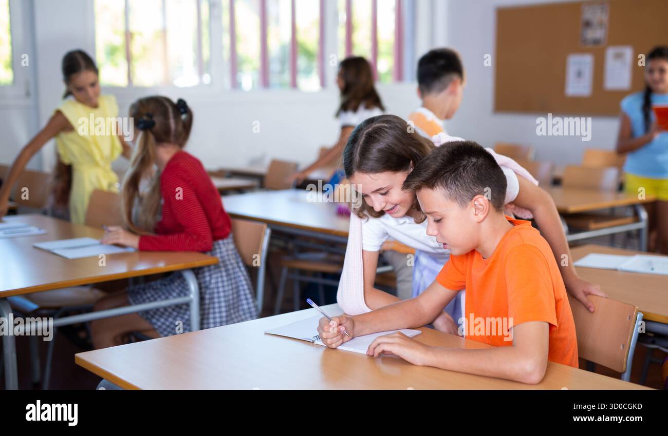 Schoolchildren help each other solve the task in classroom Stock Photo ...