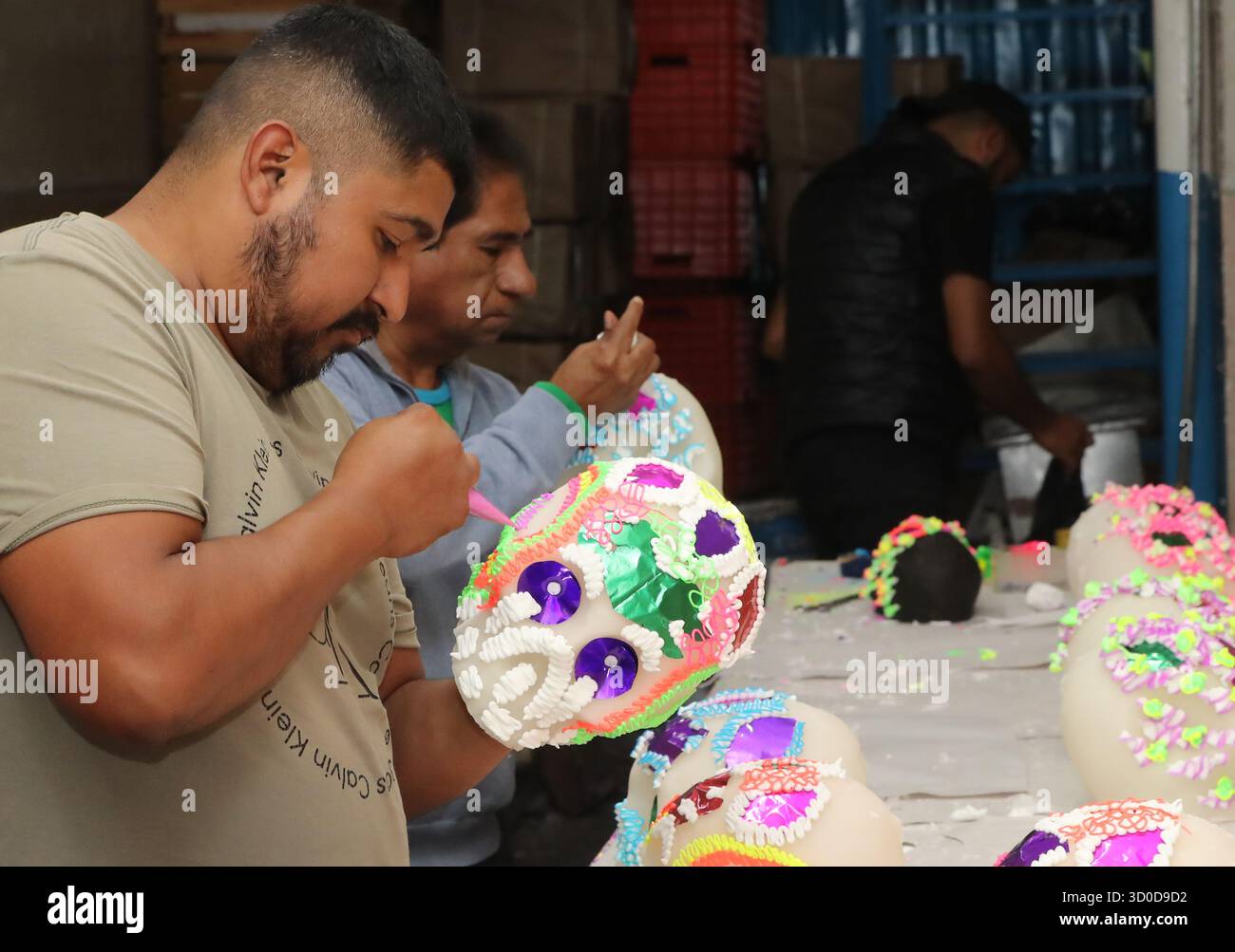 Non Exclusive: A worker of candy store Hermanos Jimenez decorates a sugar skull as part of the sugar skull production for the Dia de Muertos celebrati Stock Photo