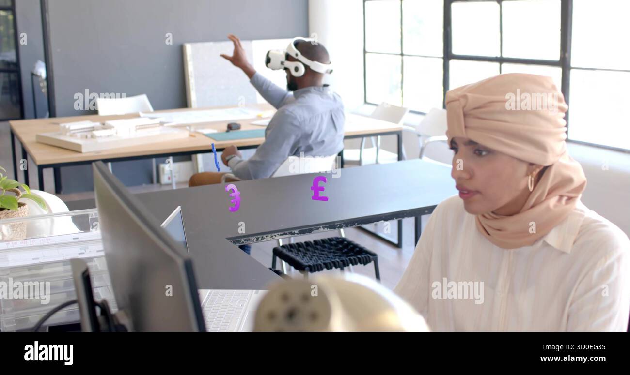 Working Asian Indian woman typing on computer at office, with VR headset, scale models, copy space Stock Photo