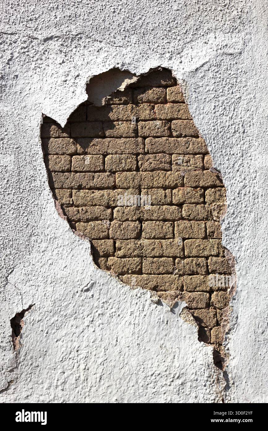 Structural damage, wall damage, flaking plaster and wall paint, bricks Stock Photo