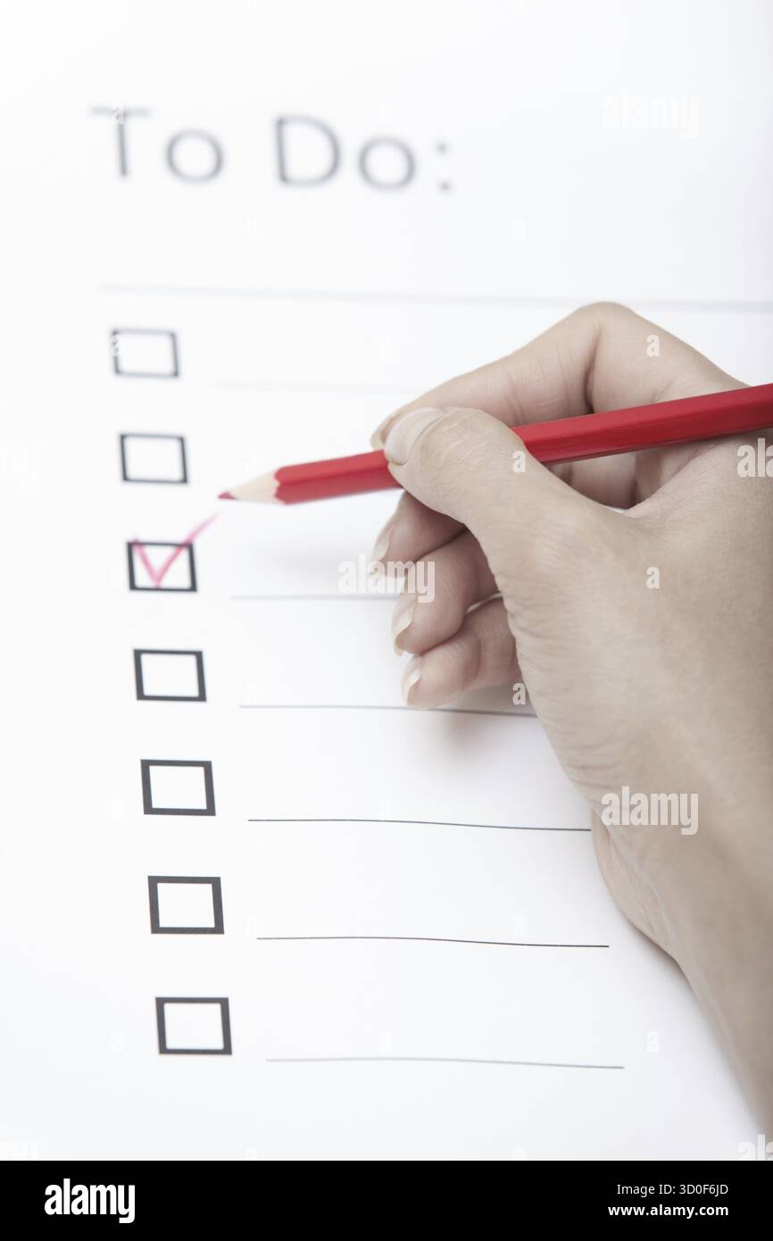 Human hand writing on a checklist document Stock Photo