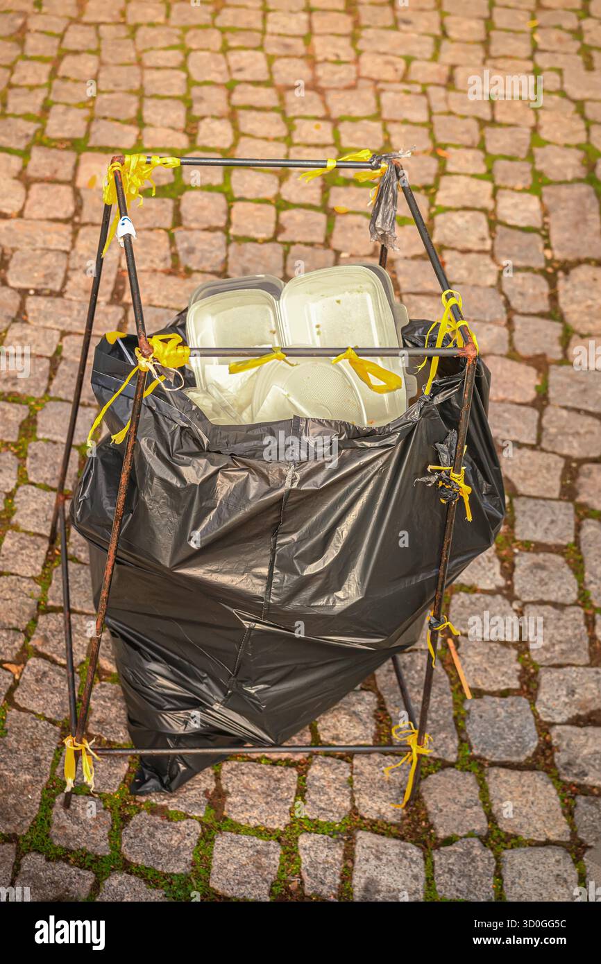 Open trash bag filled with used plastic food containers and disposable ...