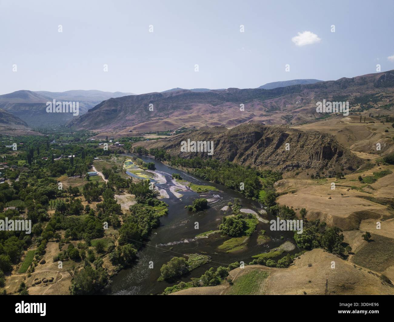Aerial view of the winding river snaking through a valley of golden ...