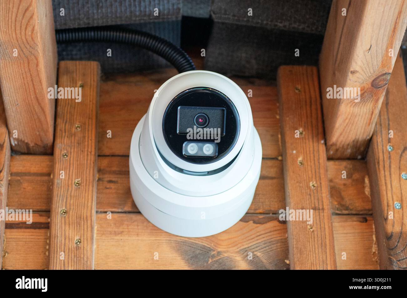 Security camera mounted on a wooden structure. Stock Photo