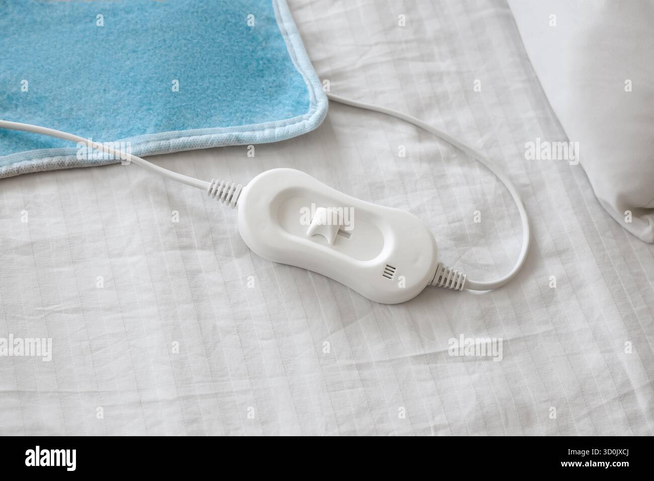 Modern electric heating pad on bed, top view Stock Photo