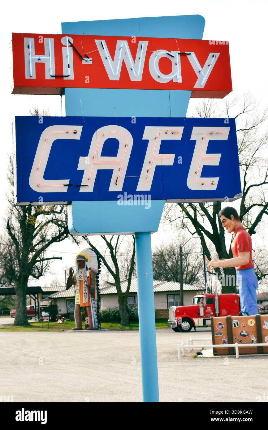 A blue and red neon sign for the Hi-Way Cafe sits in front of a muffler ...
