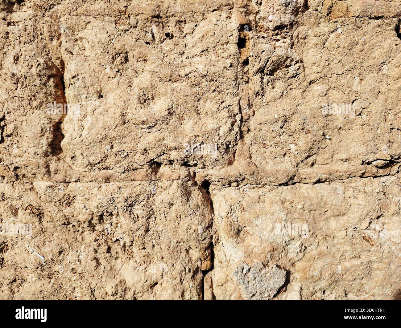Rough textured adobe or mud brick wall closeup background. Stock Photo