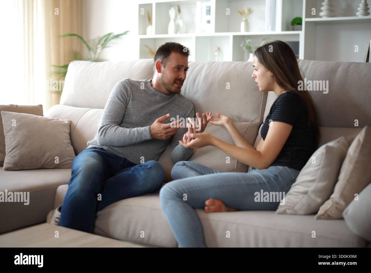 Sad couple arguing sitting on a couch at home Stock Photo
