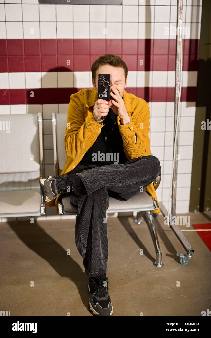 Young man taking a photo in a modern indoor setting Stock Photo