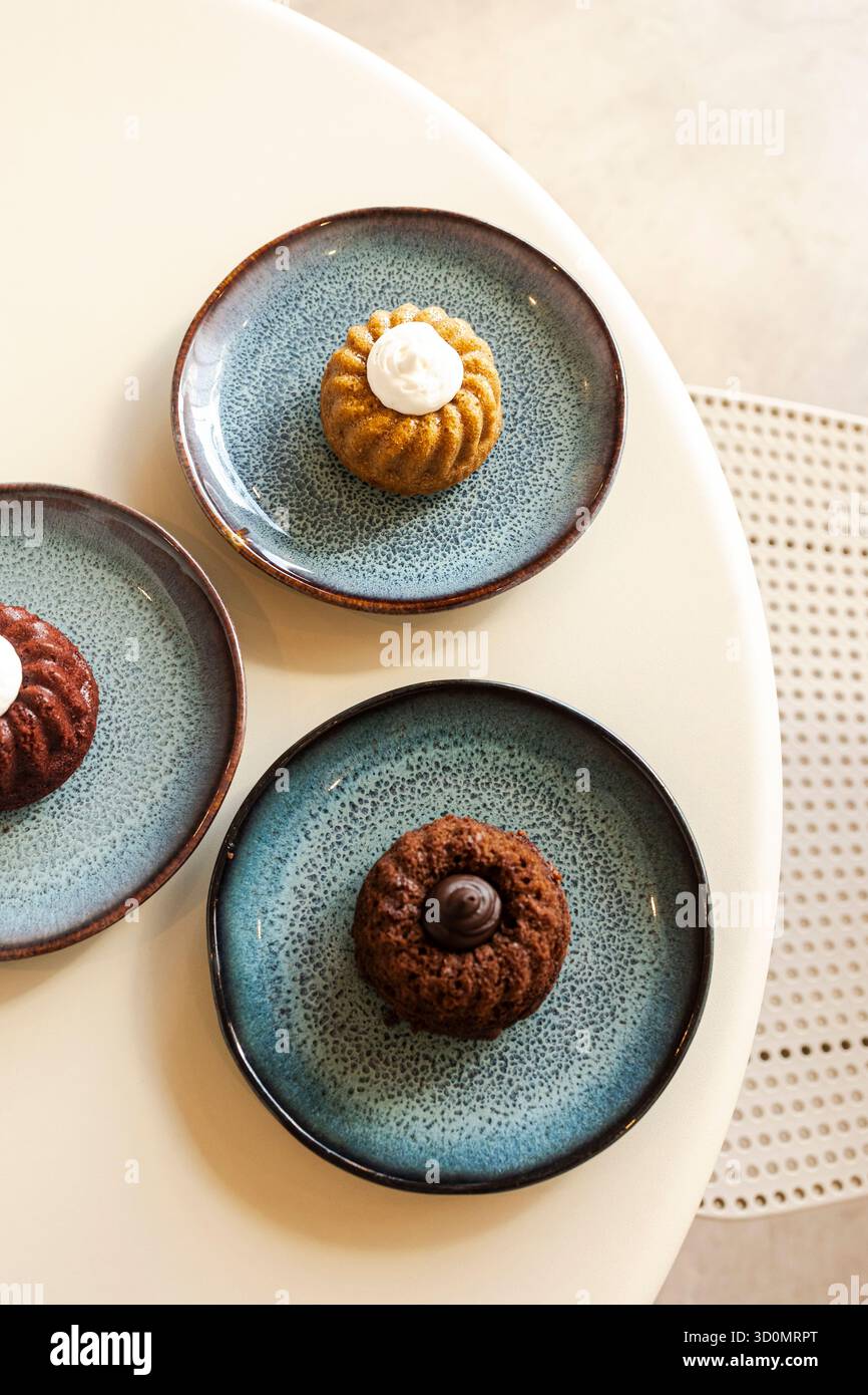 Mini bundt cakes on blue ceramic plates Stock Photo