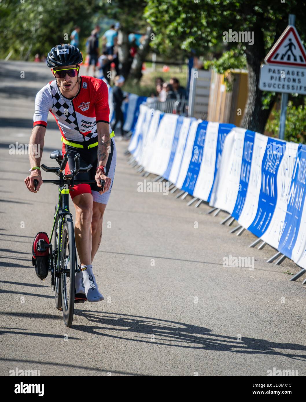 Triathlete dismounting from their bike at the transition zone in the Man VAR Triathlon in Gorges du Verdon, France. Stock Photo