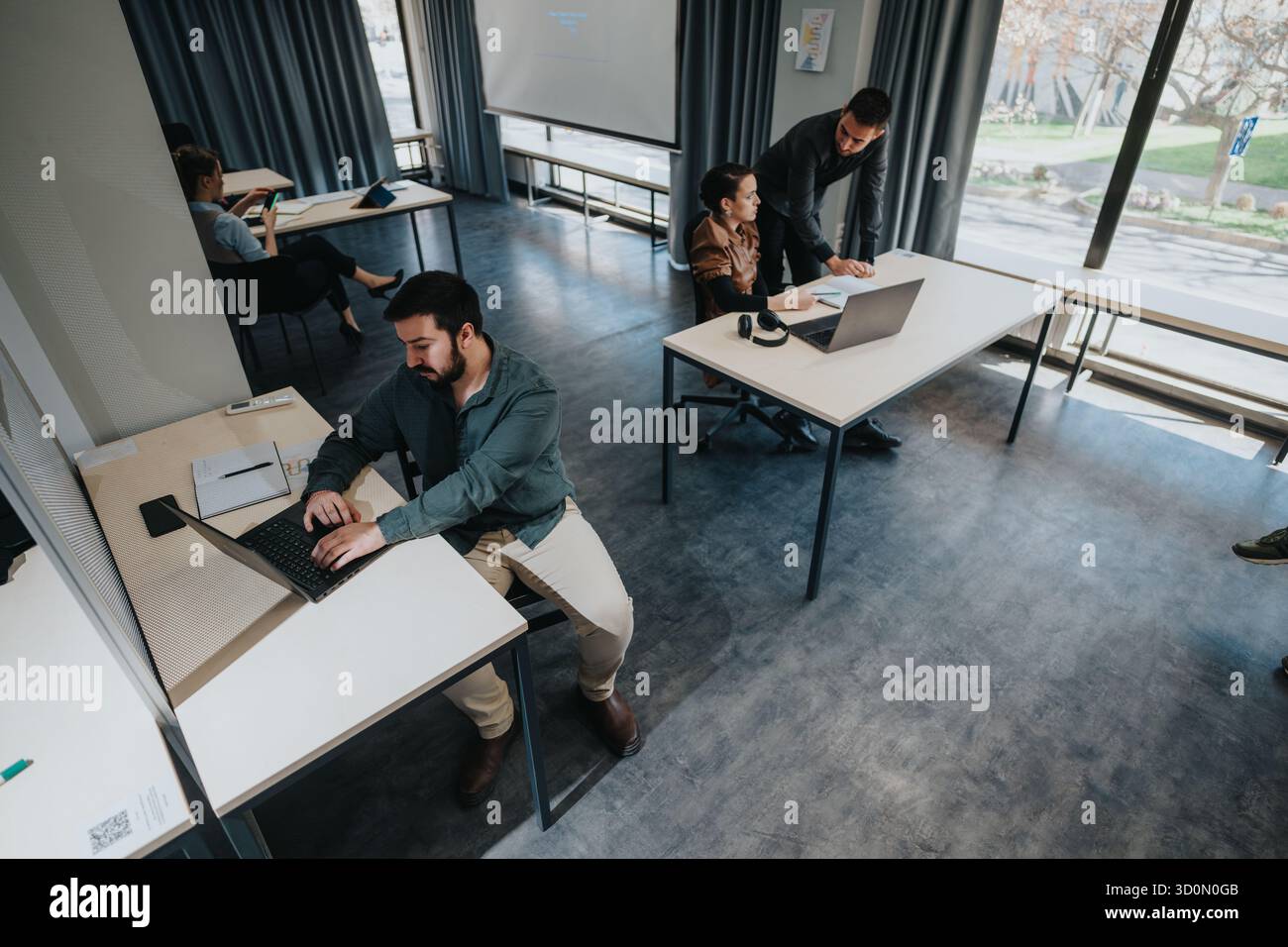 Team collaborating and working on projects in a modern office setting Stock Photo