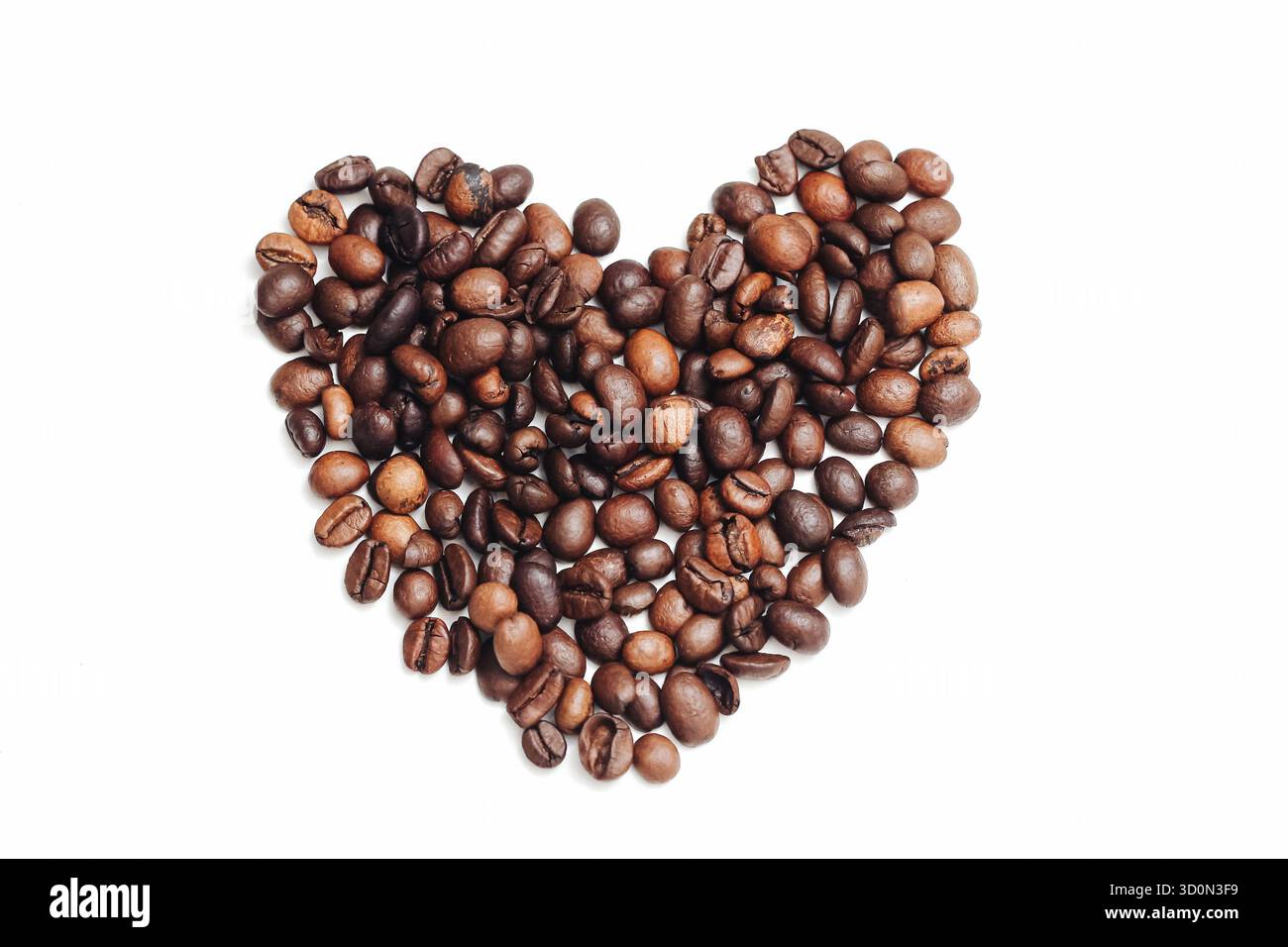 Coffee beans heart shape. Roasted arabica beans. Brown beans on white. Love coffee concept. Cafe background mockup. Minimal food flat lay. Stock Photo