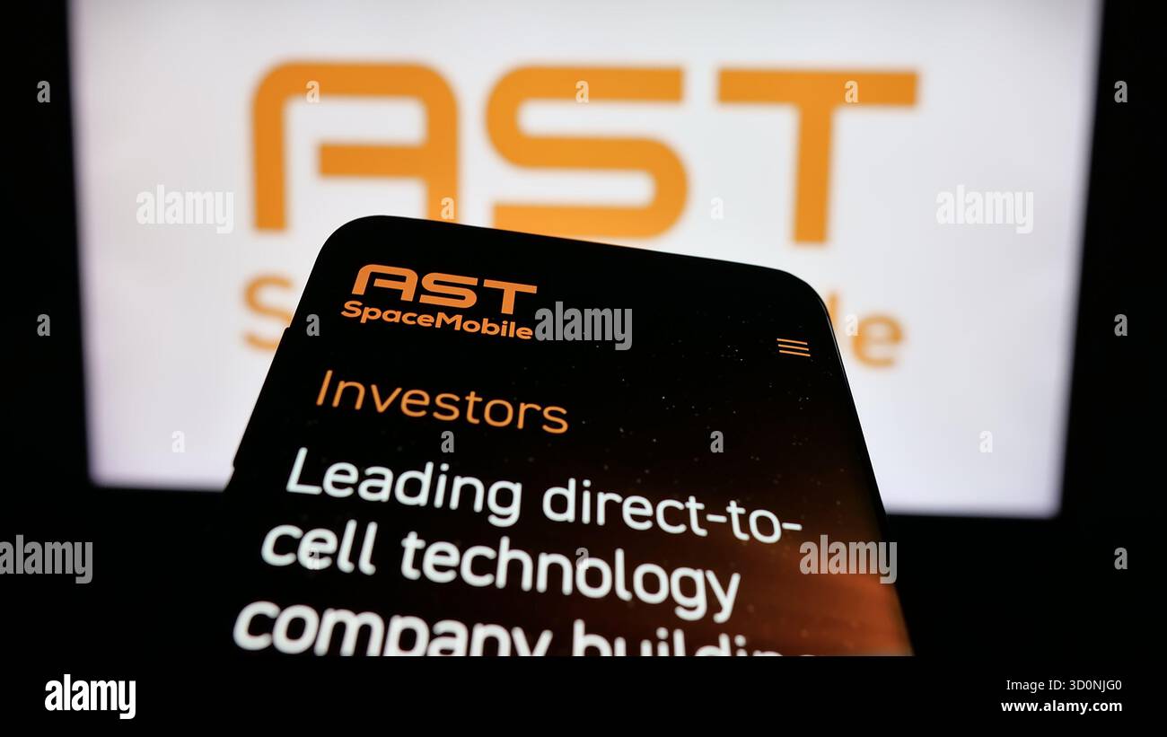 Stuttgart, Germany - 10-18-2025: Mobile phone with website of US satellite company AST SpaceMobile Inc. on screen in front of logo. Focus on top-left Stock Photo