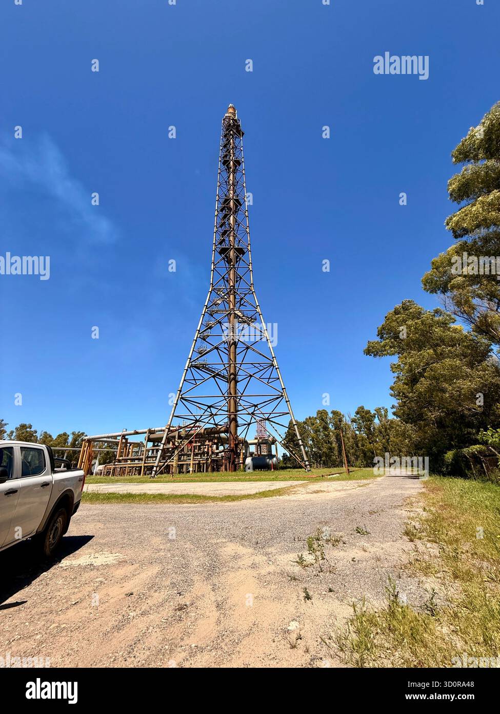 Industrial flare stack tower at a petrochemical plant under clear blue sky - Smartphone Captured Stock Image