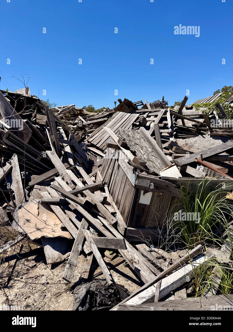 Pile of collapsed wooden debris under blue sky - Smartphone Captured Stock Image