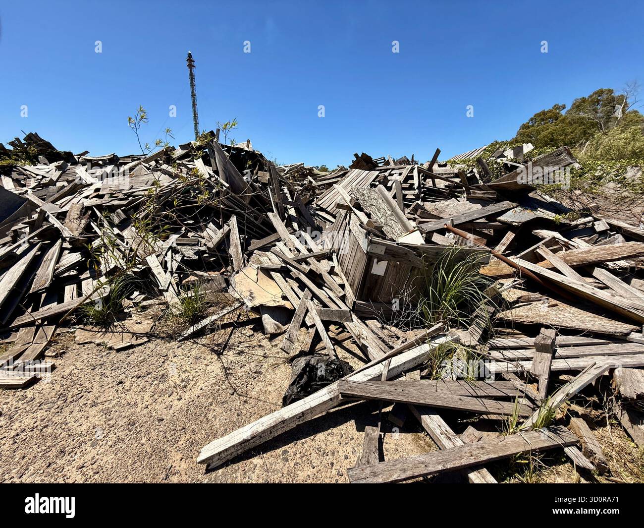 Pile of collapsed wooden debris under blue sky - Smartphone Captured Stock Image