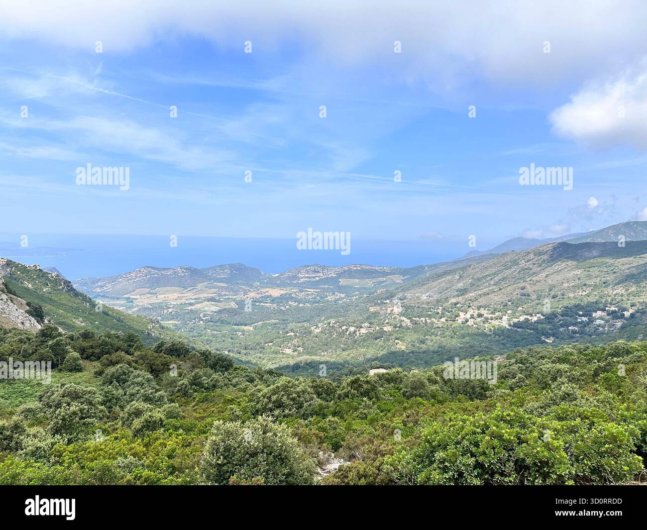 Scenic landscape from a mountain top on Corsica Island with a panoramic view of the blue Mediterranean Sea on a sunny day. - Smartphone Captured Stock Image