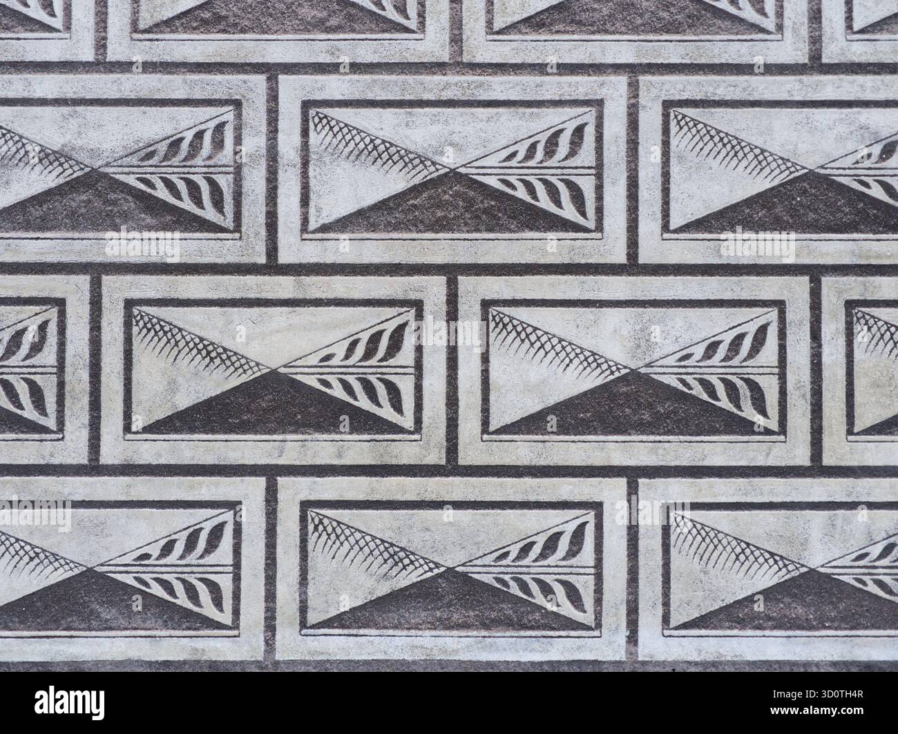 Repeating geometric pattern with triangular designs in rectangular frames on architectural surface Stock Photo
