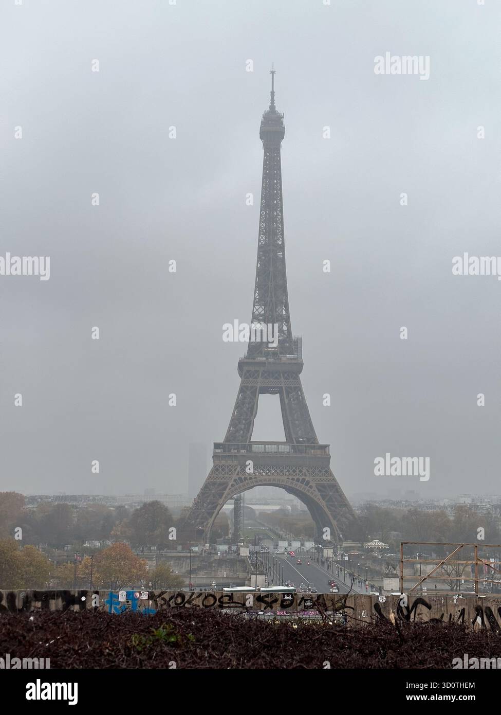 View of the Eiffel tower in Paris, France behind graffitied wall - Smartphone Captured Stock Image