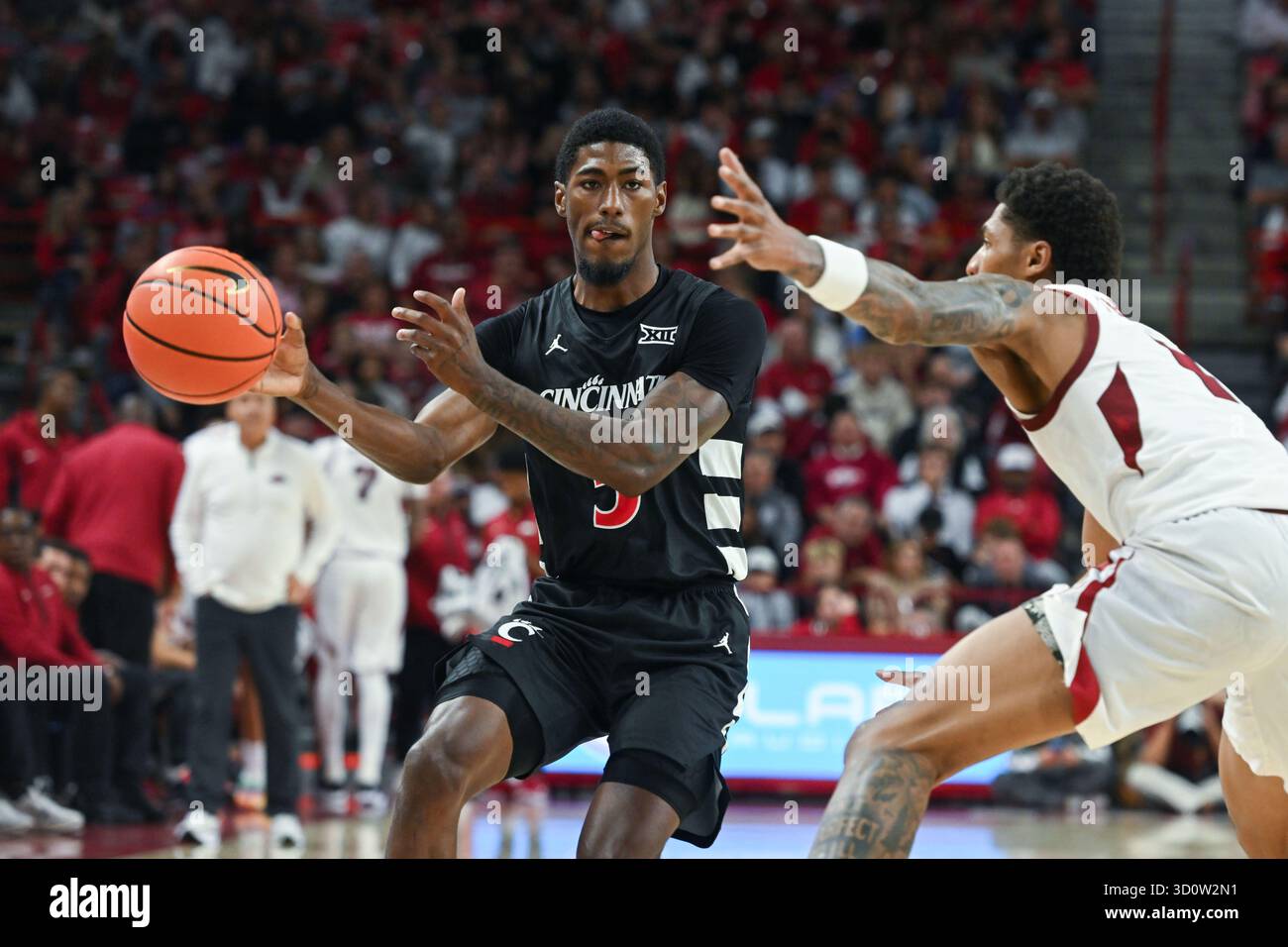 Cincinnati guard Sencire Harris, left, tries to drive past Arkansas ...