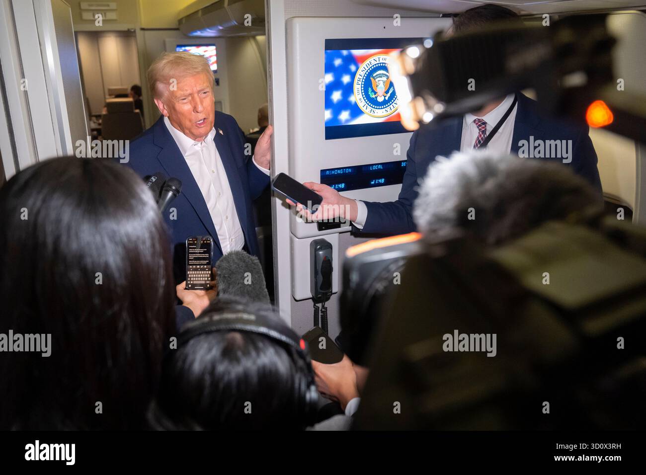 President Donald Trump speaks to reporters aboard Air Force One en ...