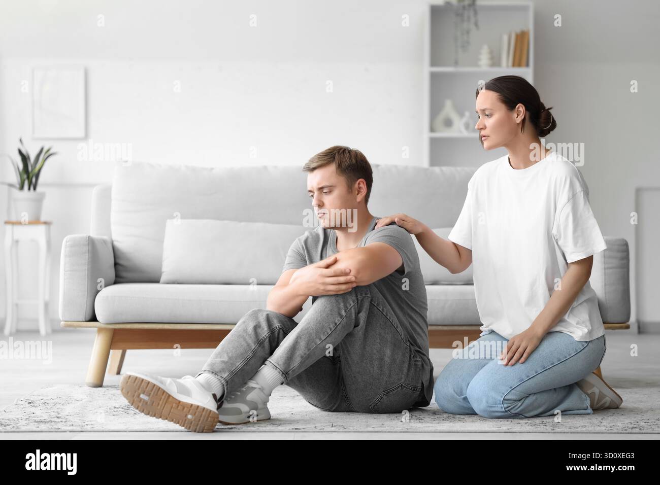 Young woman supporting man with suicidal thoughts at home Stock Photo