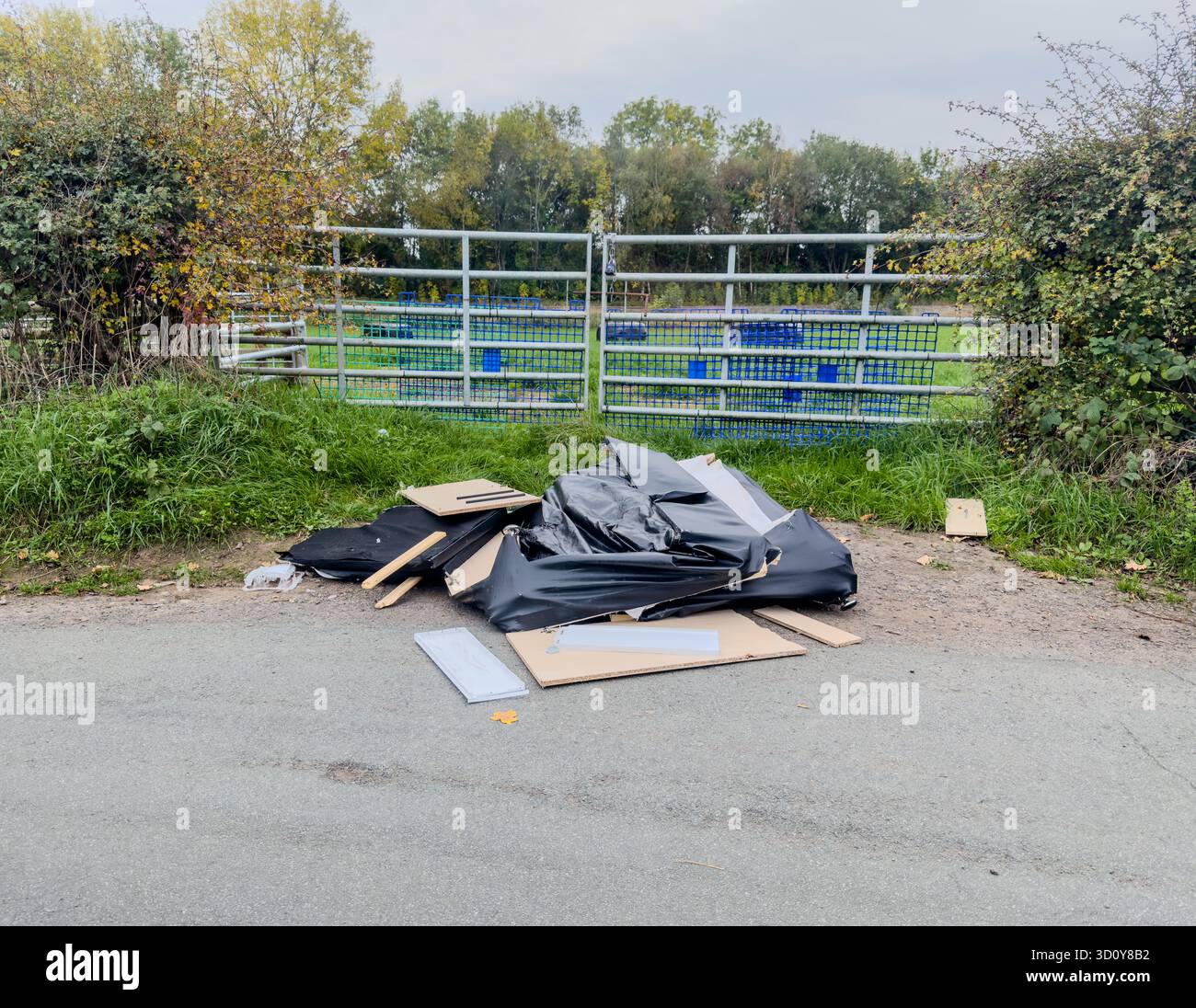 A pile of fly tipped items dumped in a gateway to a farmers field. - Smartphone Captured Stock Image