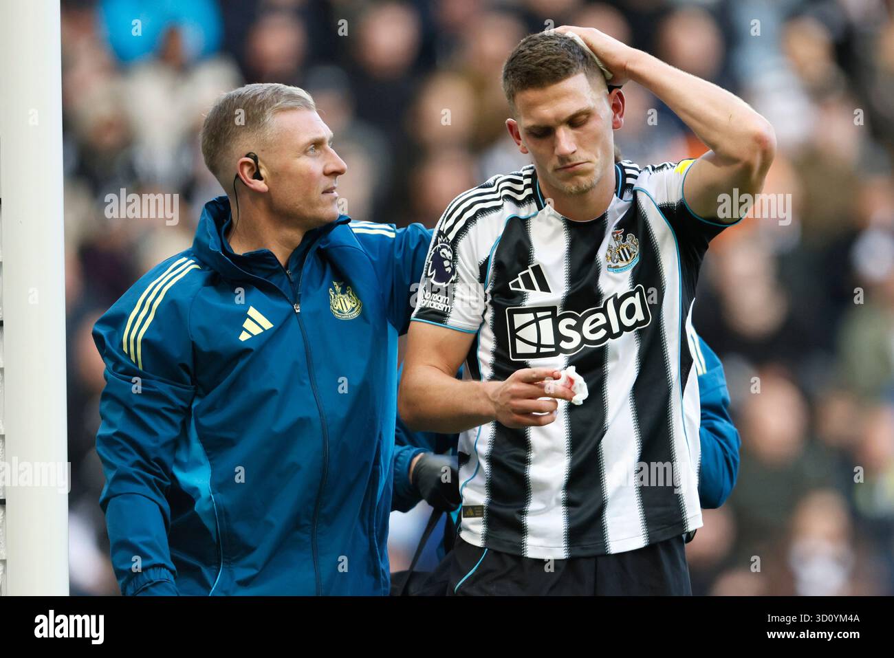 Newcastle United's Sven Botman walks off the field with the medical ...