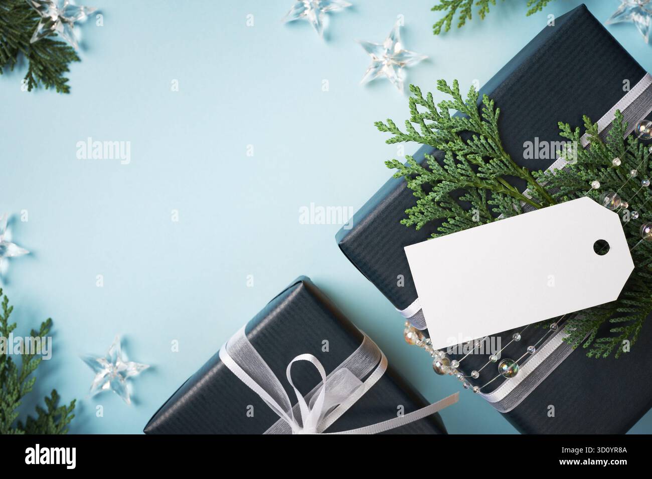 Blue present boxes with empty gift tag on light blue background. Space for your text. Stock Photo