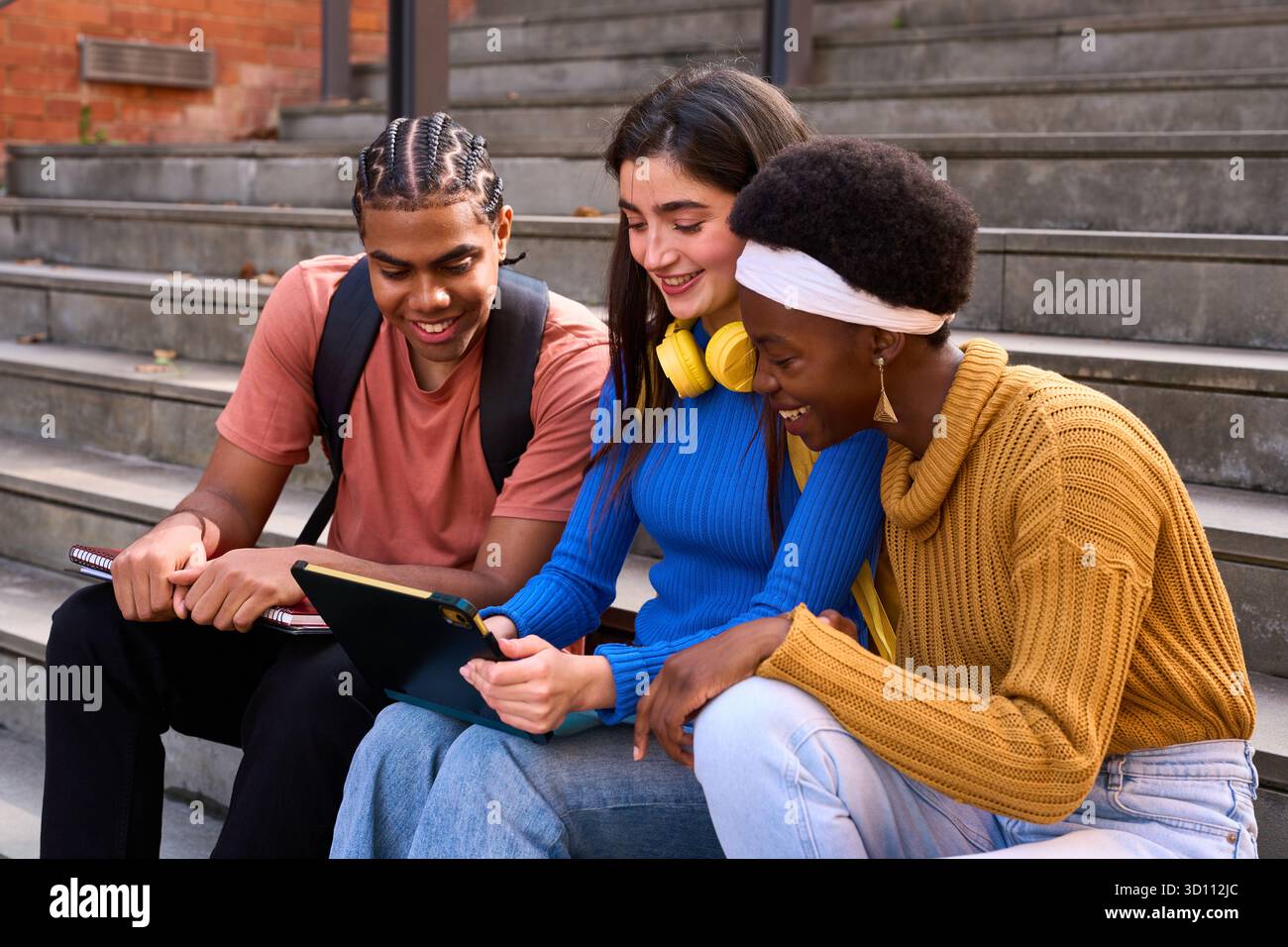 Diverse students studying together using digital tablet Stock Photo