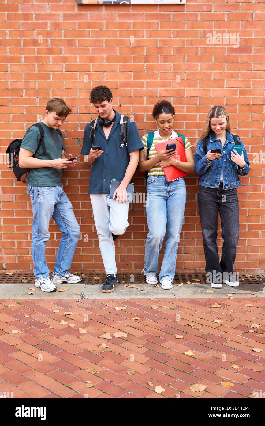 University students using mobile phones on campus Stock Photo