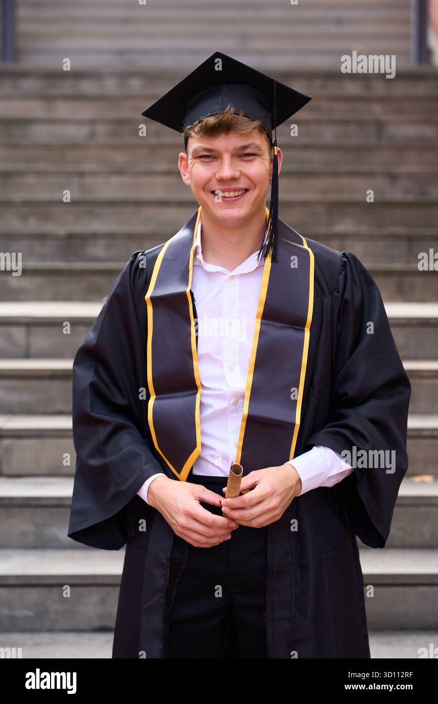 Happy male graduate holding diploma celebrating achievement Stock Photo ...