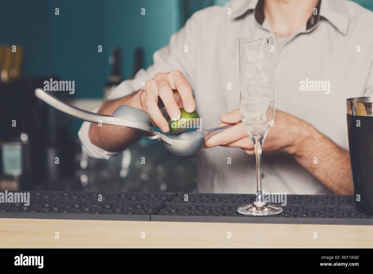 Bartender making cocktail with lime, close-up Stock Photo