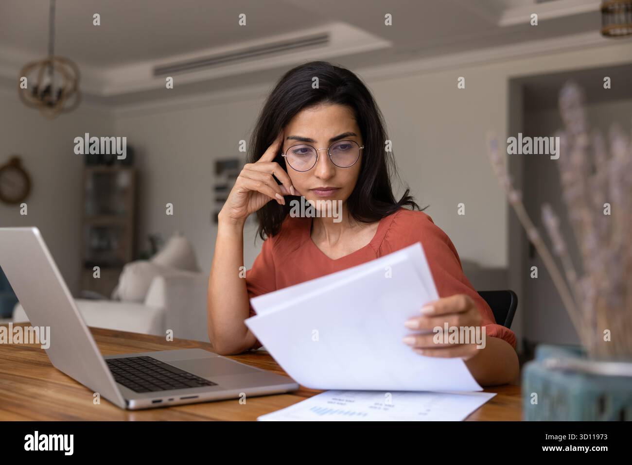 Focused thoughtful young Latin professional woman working on project Stock Photo