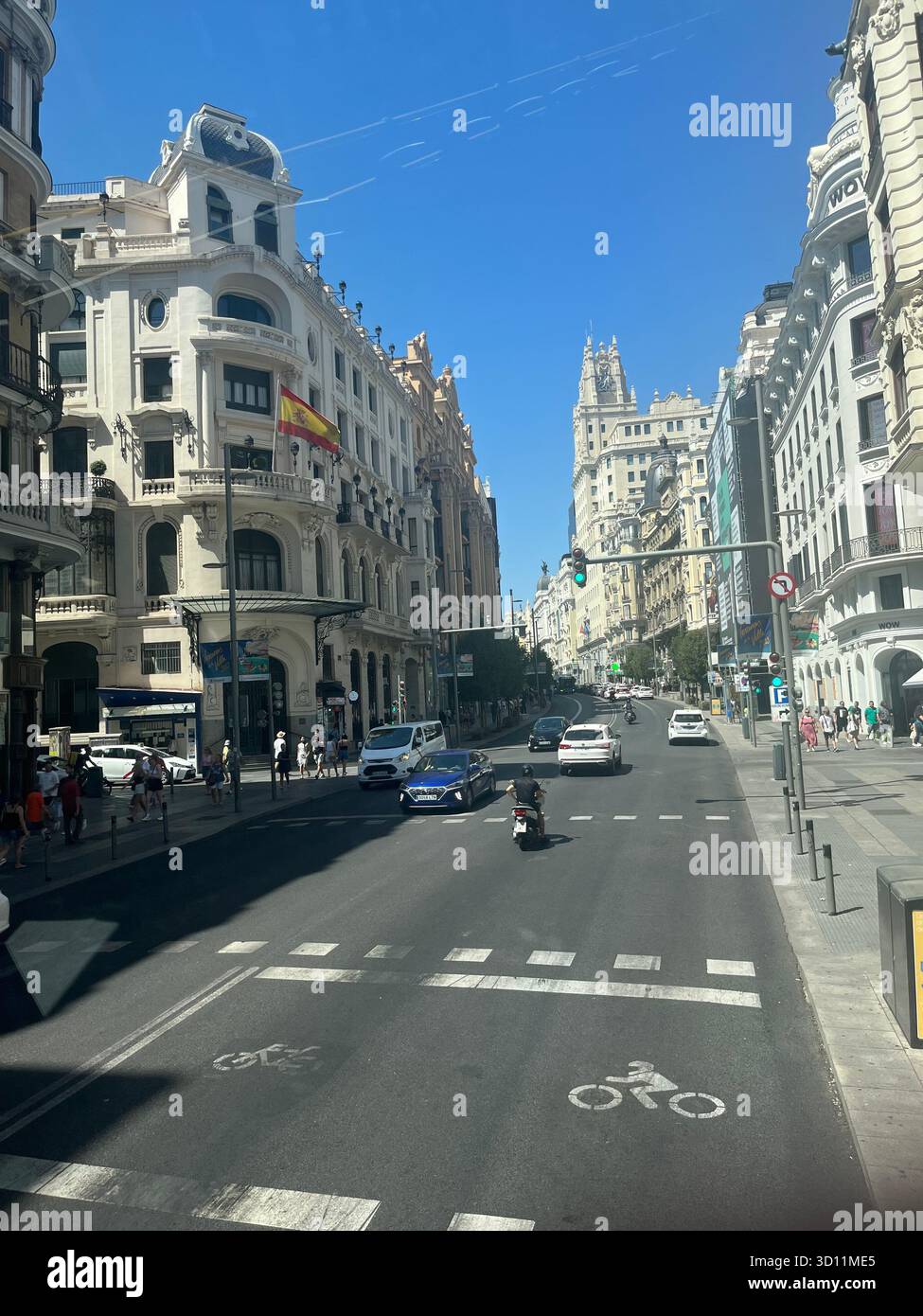 Street view of lower Gran Vía in Madrid, Spain, on a sunny summer day, showing the iconic architecture and vibrant city atmosphere. - Smartphone Captured Stock Image