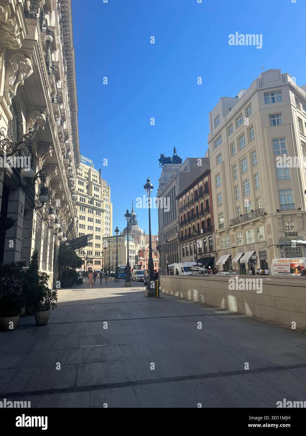 Street view in central Madrid, Spain, showing elegant historic architecture and bright summer light under a clear blue sky. - Smartphone Captured Stock Image