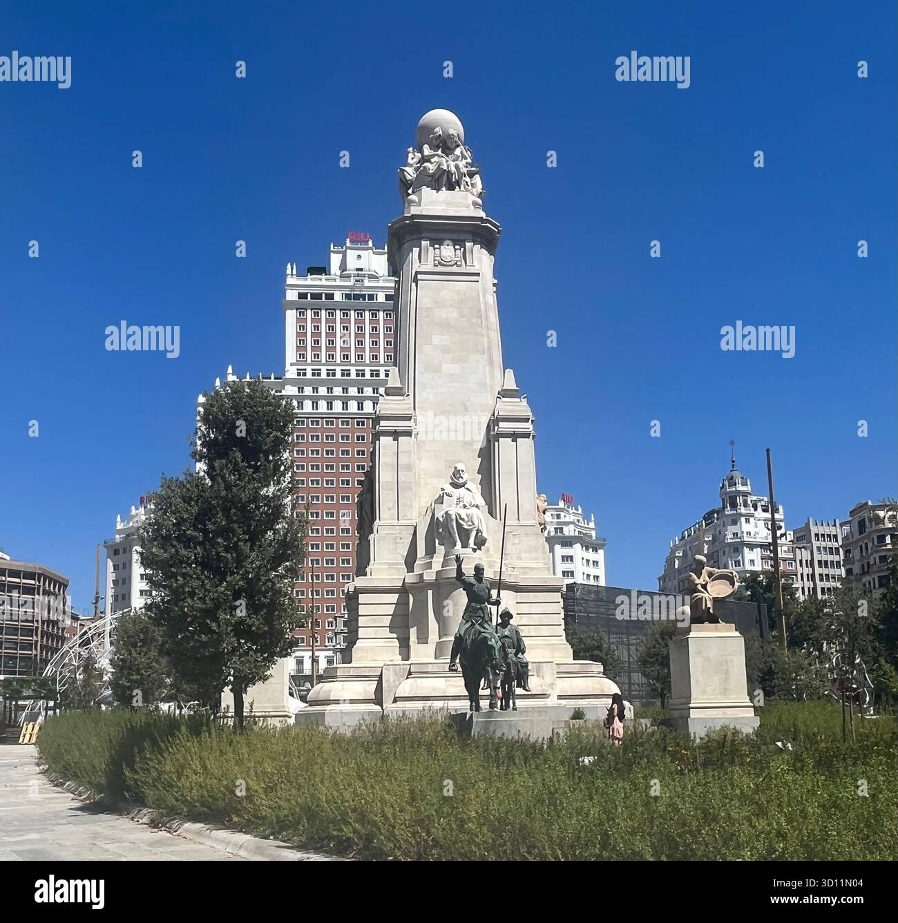 Front view of the Monumento a Cervantes at Plaza de España in Madrid, Spain, with the Riu Plaza España Hotel in the background on a sunny summer day. - Smartphone Captured Stock Image