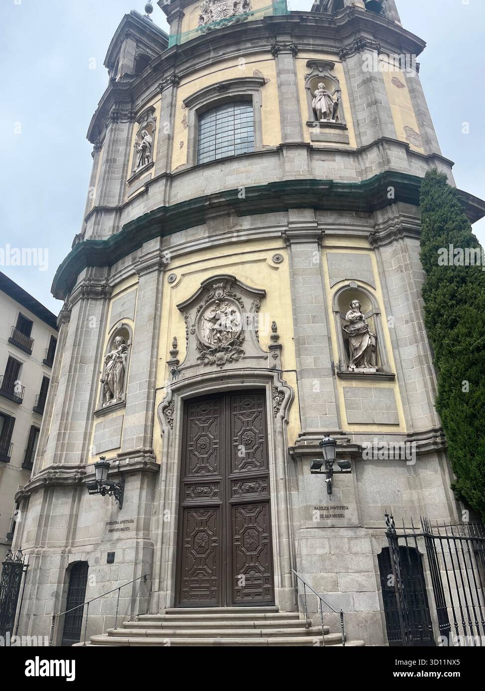 Curved Baroque Façade of Basílica Pontificia de San Miguel in Madrid with Sculptures and Ornate Stone Details on a Quiet City Day. - Smartphone Captured Stock Image