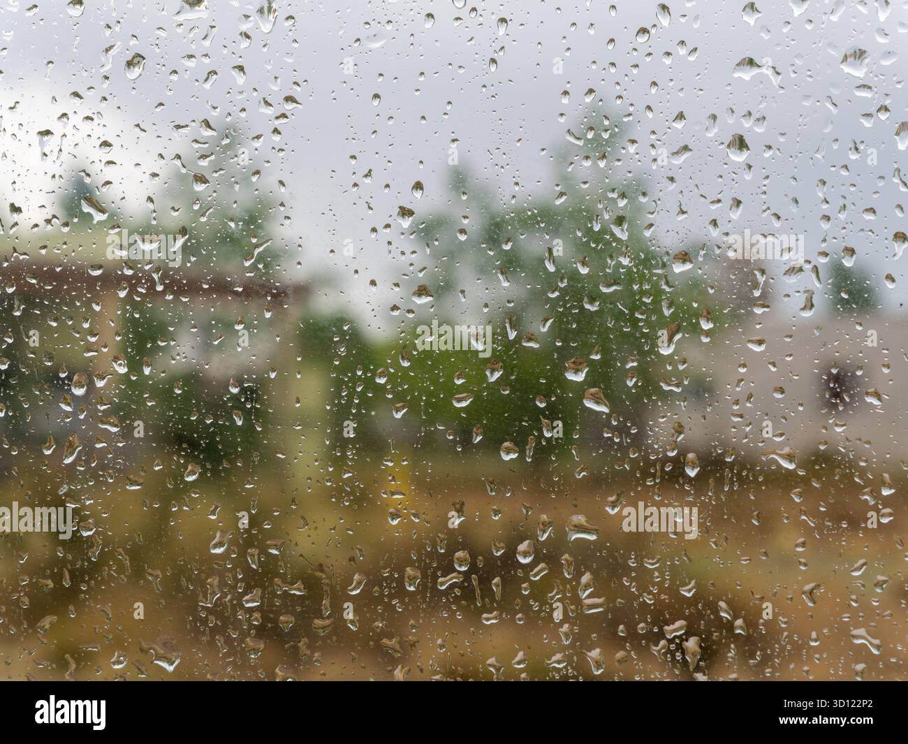 Glass Raning Water drops covering a glass window, revealing a soft focus background ...
