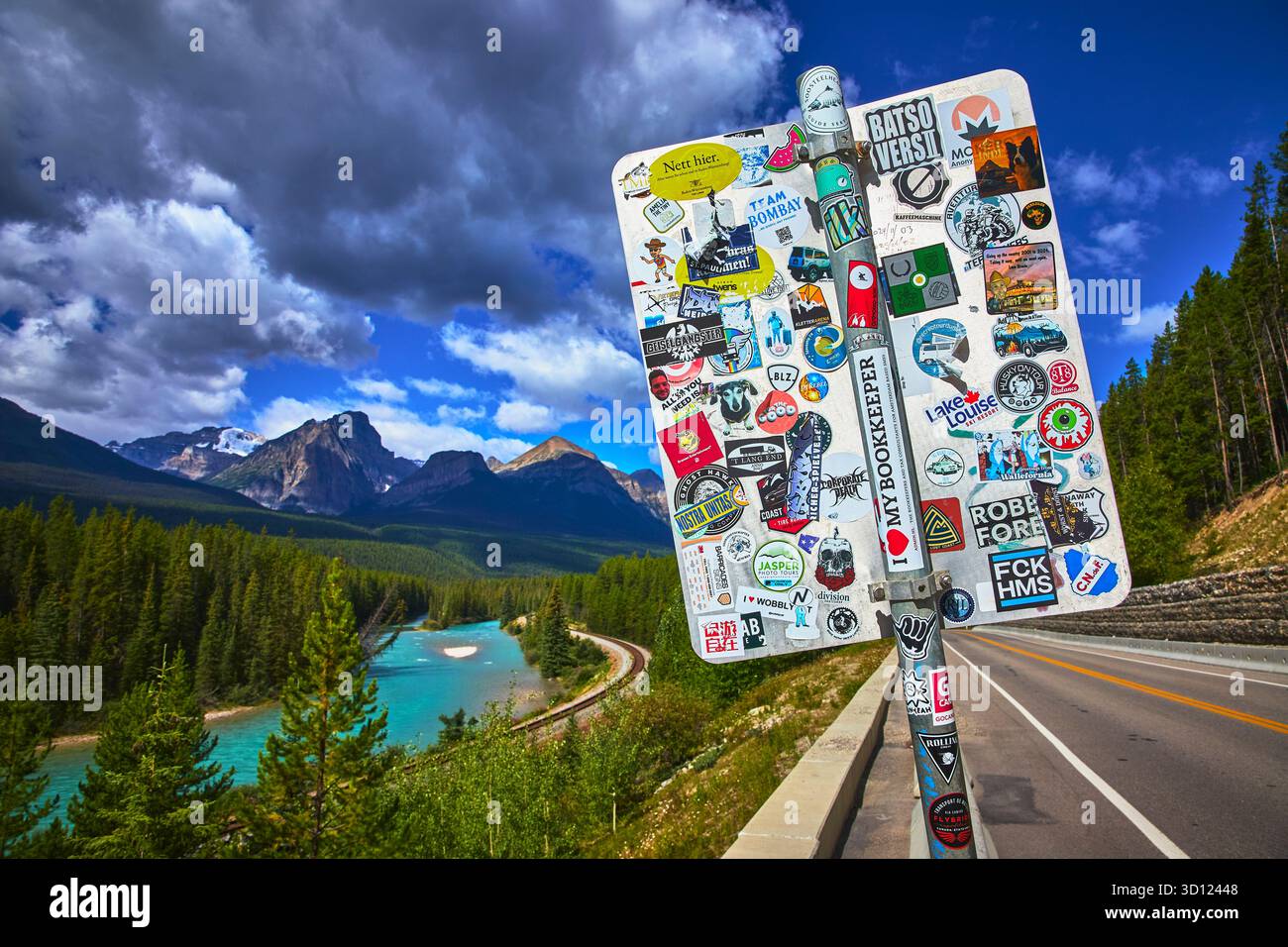 Sticker Covered Sign at Morant's Curve with Train Track and Mountain Scenery Stock Photo