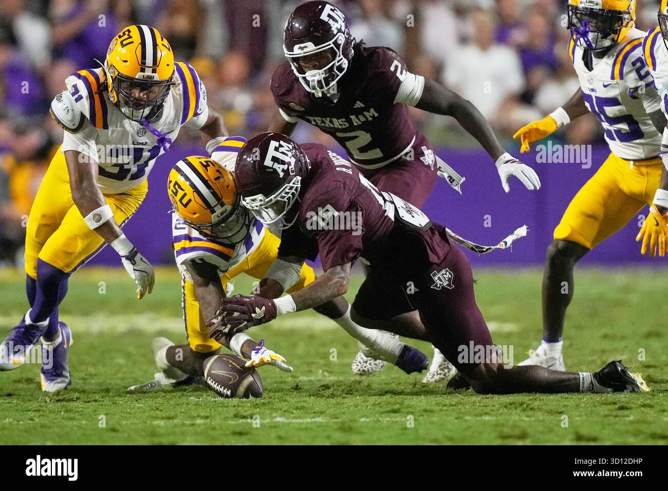 LSU's PJ Woodland and Texas A&M's Bravion Rogers (19) dive for a fumble ...