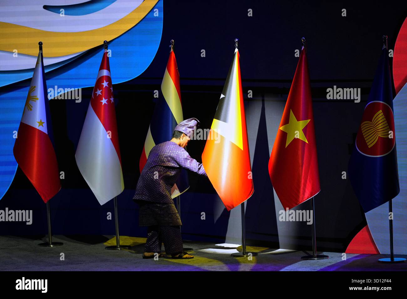 A man arranges flags during the 47th ASEAN summit opening day in Kuala ...
