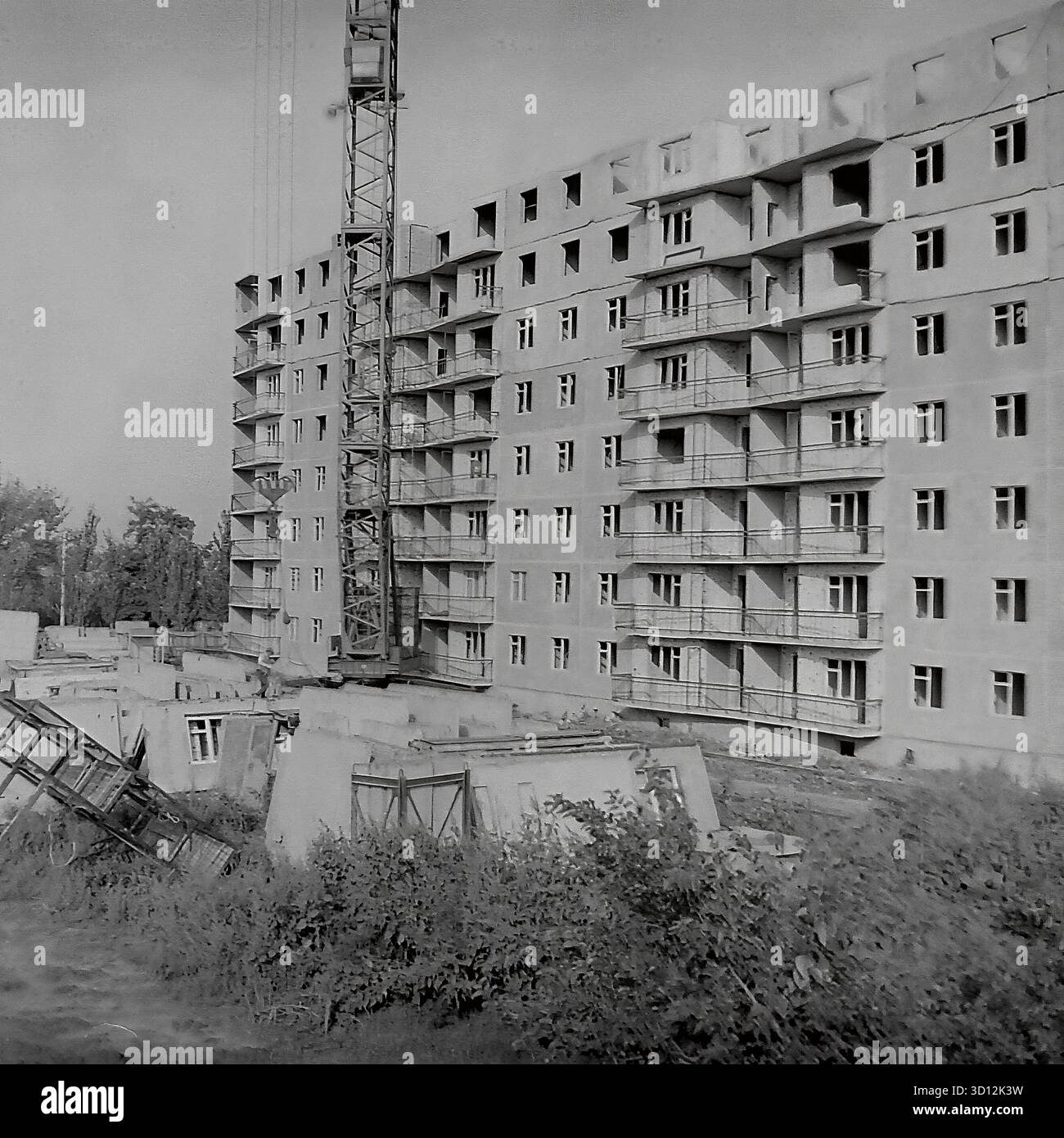A large tower crane builds a new multi-story panel apartment building ...